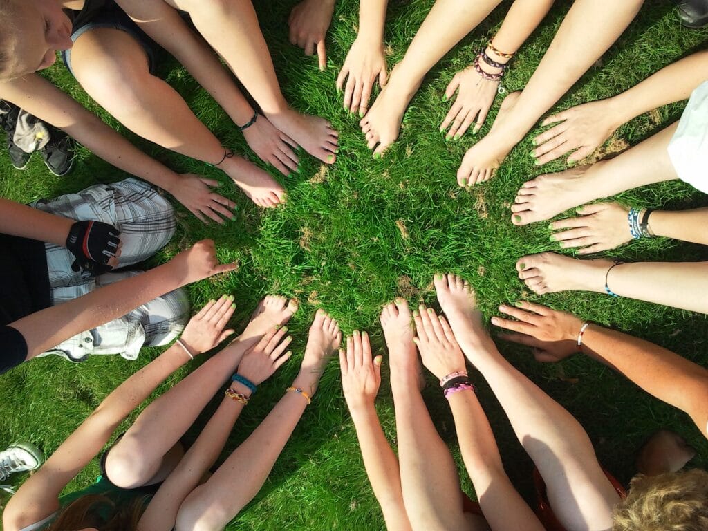 pieds-mains Un groupe d'adolescents assis en cercle avec leurs pieds et leurs mains en posés au sol